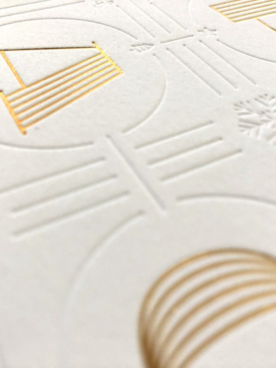 Close up on the beveled printed design on white card showing texture