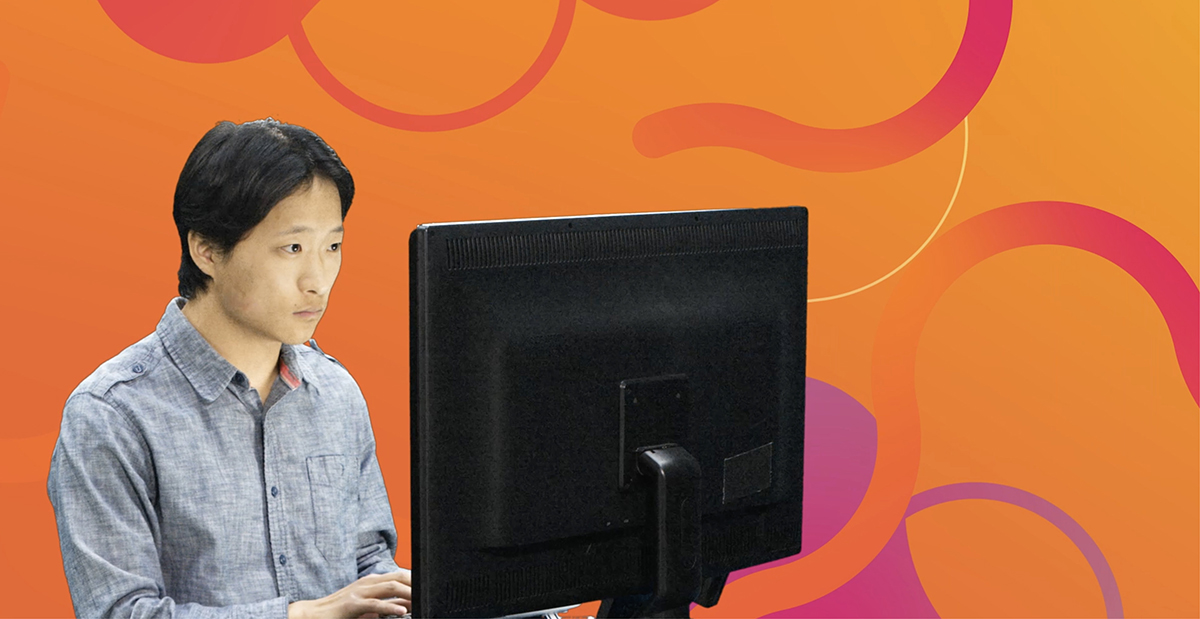 Man working on desktop computer with abstract vector designed orange and purple background