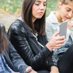 modern young women focused using mobile phones